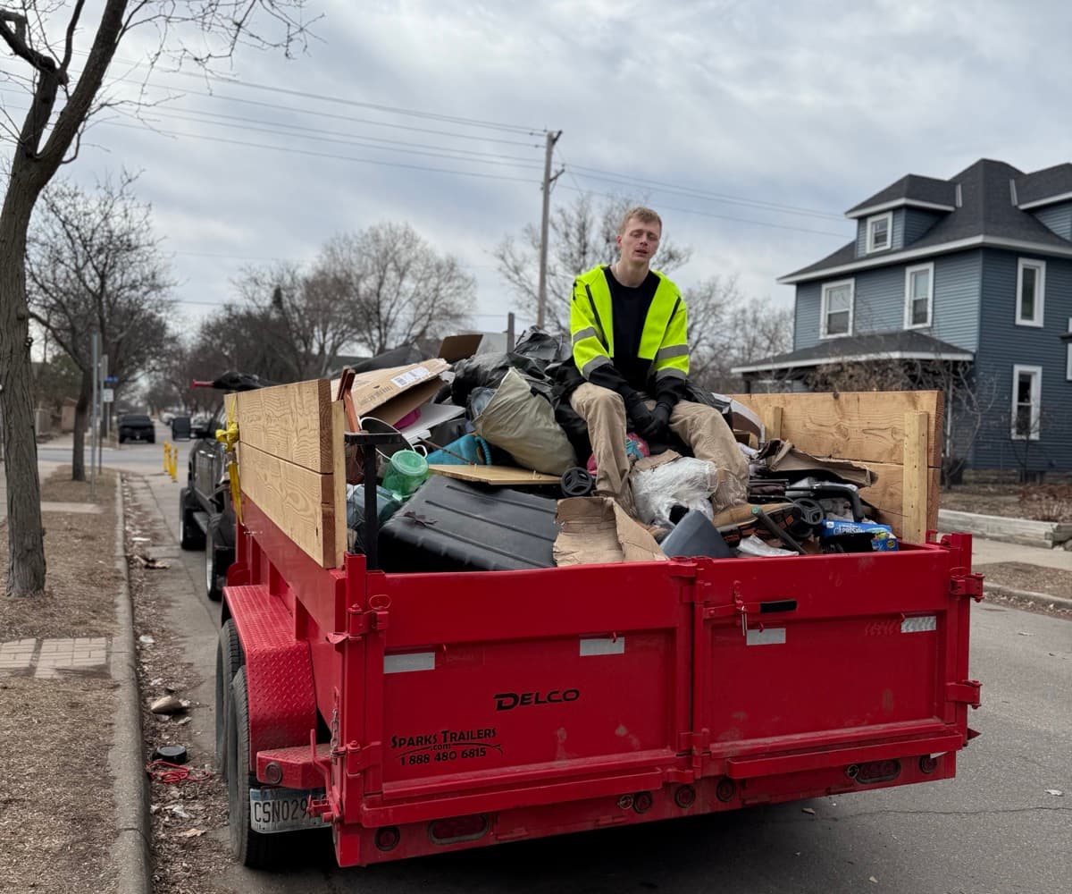 SDJ Junk and Waste team member on loaded red trailer
